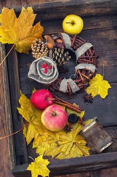 Woven autumn wreath amid fallen maple leaves