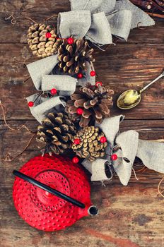 Retro red cast iron kettle and cane wreath with cones