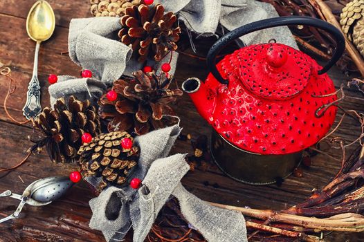 Retro red cast iron kettle and cane wreath with cones
