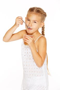 Beautiful little girl with pigtails eating jelly
