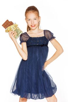 Beautiful blonde girl in a blue dress with curls eating a chocolate