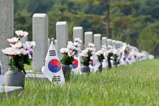 Flags and artificial flowers at Seoul National Cemetery with selected focus