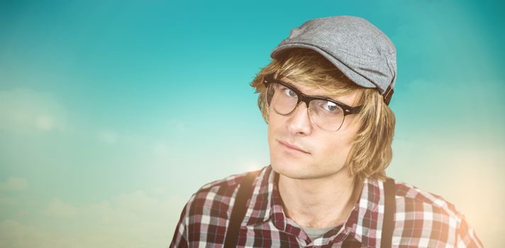 Serious blond hipster staring against blue green background