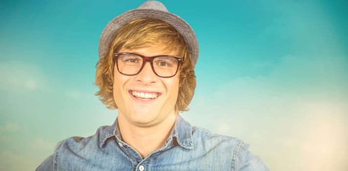 Smiling blond hipster staring at camera against blue green background
