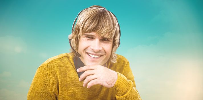 Smiling hipster businessman using headset against blue green background