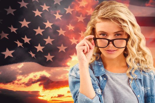 Portrait of businesswoman wearing eyeglasses posing  against composite image of united states of america flag