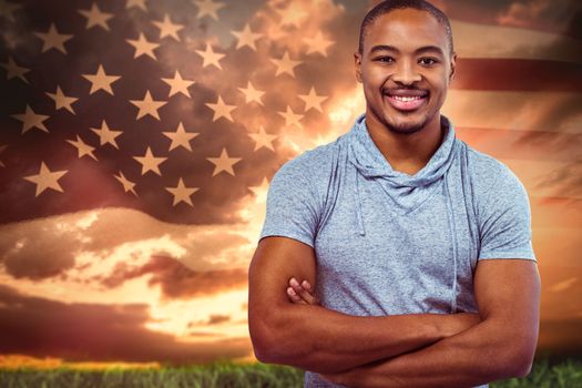 Smiling man with arm crossed on white background against composite image of united states of america flag