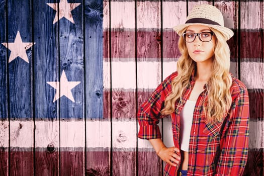 Gorgeous blonde hipster with hand on hips against composite image of usa national flag