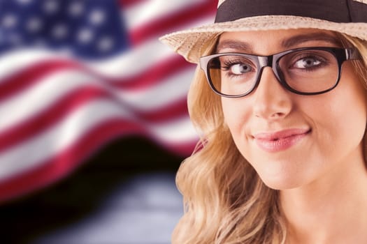 Gorgeous blonde hipster smiling against composite image of digitally generated united states national flag