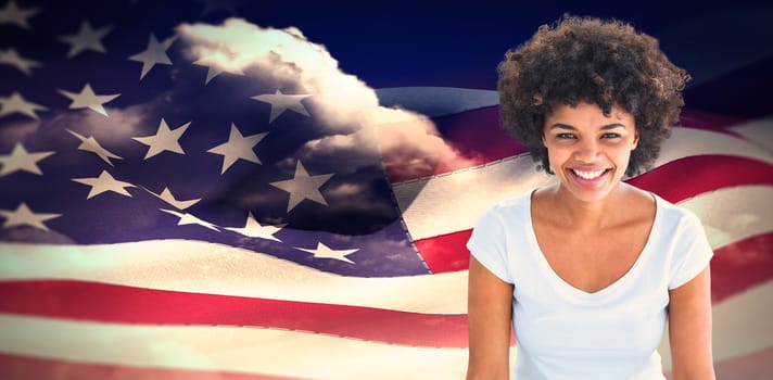 Smiling woman posing on white background against composite image of digitally generated american flag rippling