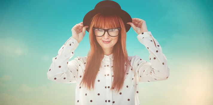 Attractive smiling hipster woman with hat  against blue green background