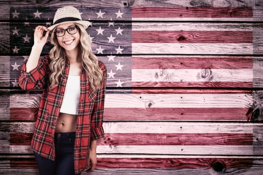 Gorgeous smiling blonde hipster posing against composite image of usa national flag