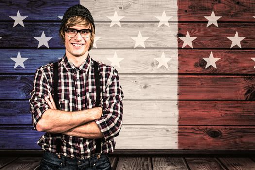 Smiling blond hipster crossing arms against composite image of usa national flag