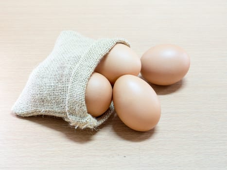 Egg in a small burlap sack. On wooden background