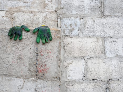 dirty gloves drying on the concrete wall