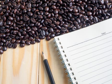 Roasted coffee beans  and memo  on wooden table