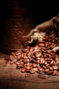 Closeup of jute sack full of coffee beans on dark background