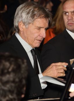 UNITED-KINGDOM, London :  Star Wars actor Harrison Ford signs autographs while Star Wars cast, crew and celebrities hit the red carpet for the last episode The Force Awakens European Premiere on December 16, 2015 in central London.   	