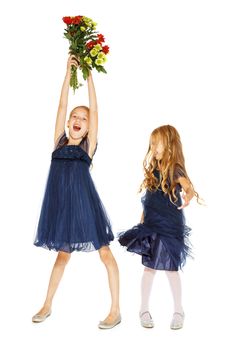 Two charming little girls in a blue dresses with a bouquet of flowers