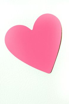 Close up shot of a pink blank heart shaped post it note.  Isolated on white background