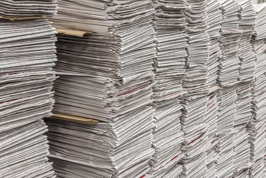 Horizontal shot of multiple stacks of newspapers