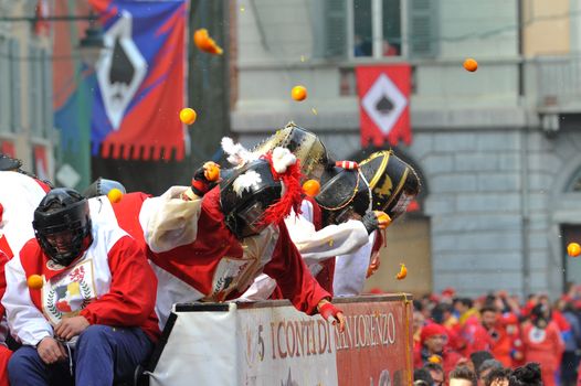 ITALY, Ivrea: People in masks throw oranges from a float during the battle of oranges in Ivrea, Italy on February 8, 2016.This unique event sees people re-enact a middle age battle using oranges. Thousands gathered in the town to pelt each other with the fruit, which is imported from Sicily. 