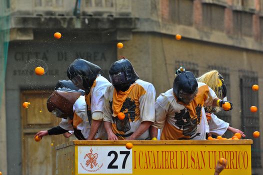 ITALY, Ivrea: People in masks throw oranges from a float during the battle of oranges in Ivrea, Italy on February 8, 2016.This unique event sees people re-enact a middle age battle using oranges. Thousands gathered in the town to pelt each other with the fruit, which is imported from Sicily. 