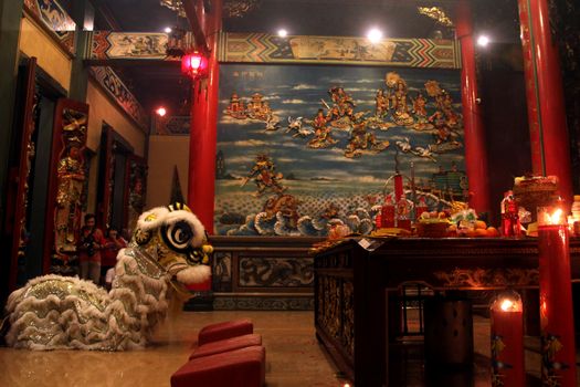 INDONESIA, Kuta: A traditional stuffed lion sits perched at a temple in Kuta, Bali, Indonesia as revelers nearby celebrate the Lunar New Year on February 8, 2016. They dance, pray, and light candles and incense as they welcome the Year of the Monkey.