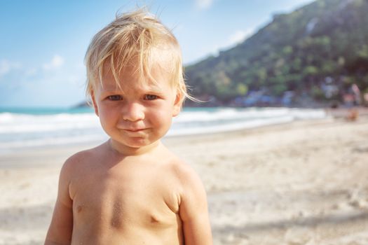 Portrait of a baby with a naked torso on the beach