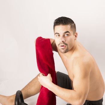 Muscle young man holding towel i on white background