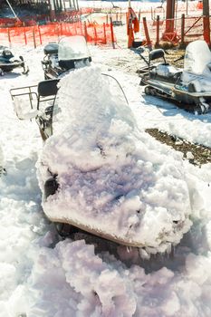 Snow cover on parked snowmobile.