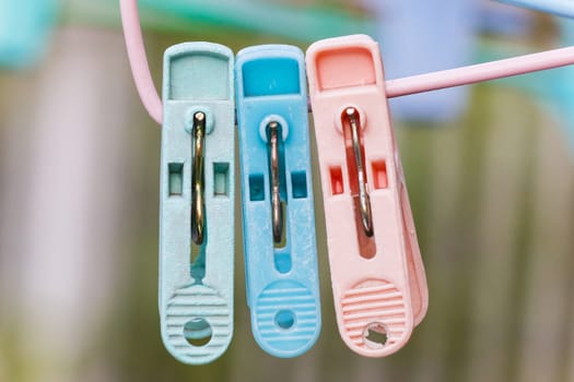 Colorful clothespin hanging on coat hanger.