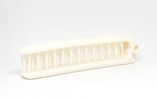 White folding comb on white background.