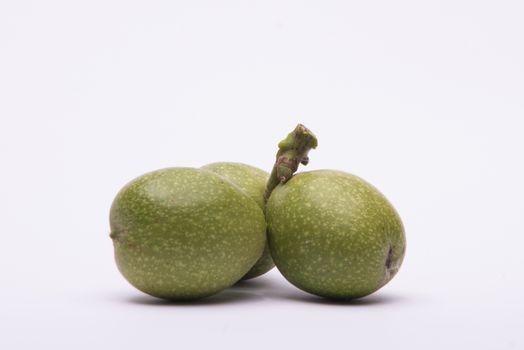 Unripe walnuts on white background