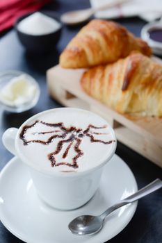 Cappuccino decorato e croissant