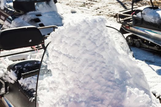 Snow cover on parked snowmobile.