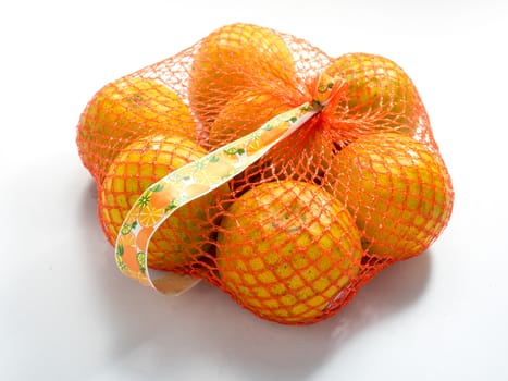 Oranges in Plastic Mesh Sack on White Background