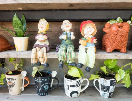 family dolls and tree pot on shelf