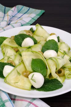 Zucchini salad with mozzarella, olives, dill and mint