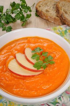 Plate of sweet pumpkin puree soup with apple