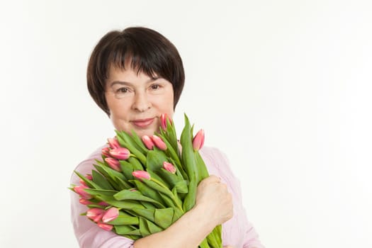 the beautiful mature woman with a bouquet of tulips