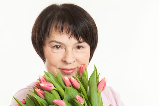 the beautiful mature woman with a bouquet of tulips