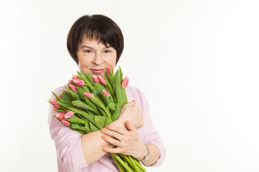 the beautiful mature woman with a bouquet of tulips