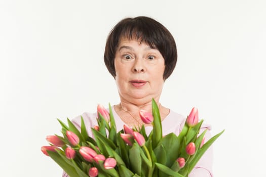 the beautiful mature woman is surprised to a bouquet of tulips