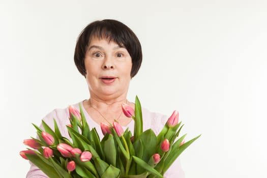 the beautiful mature woman is surprised to a bouquet of tulips