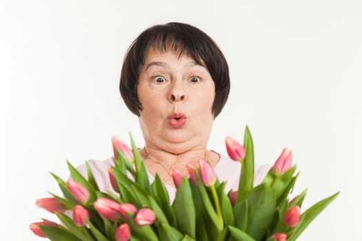 the beautiful mature woman is surprised to a bouquet of tulips