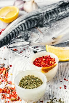 Thawed fresh fish mackerel with spices and marinade with lemon.Photograph high key