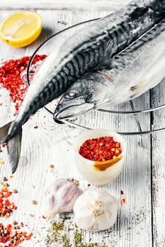 Thawed fresh fish mackerel with spices and marinade.Photograph high key