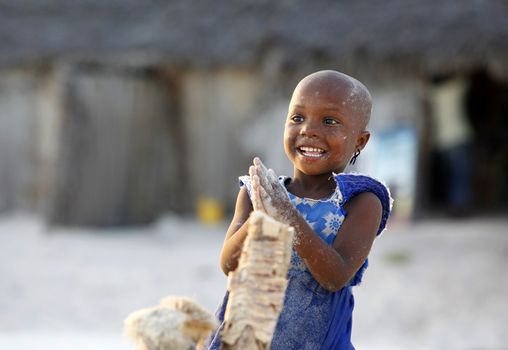 Zanzibar, Tanzania - January 9, 2016: Little cheerful African girl on the beach posing for photos Nungwi. Zanzibar