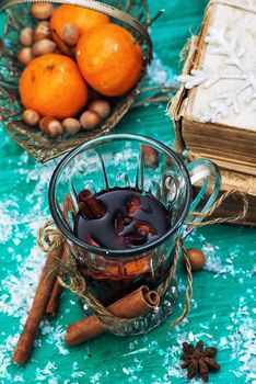 glass of mulled wine,old books and basket of ripe tangerines
